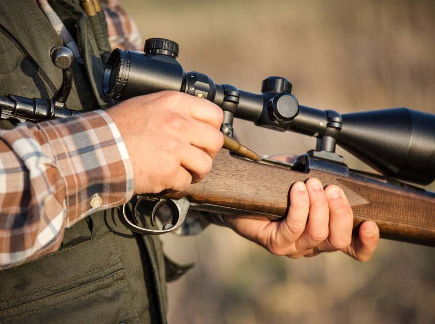 man holding a rifle with a scope